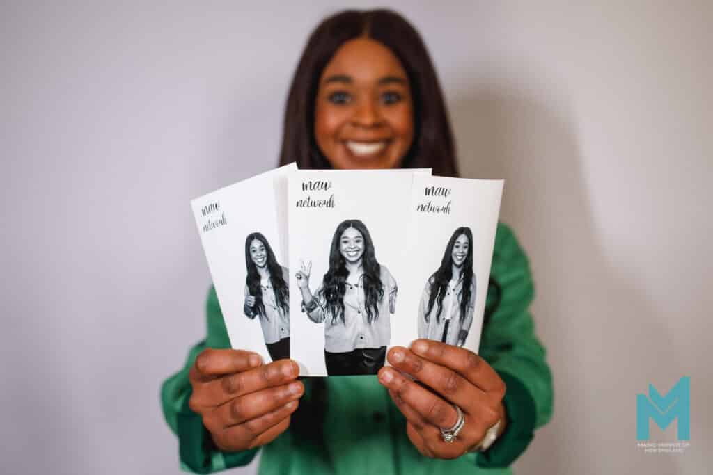 A guest at a corporate event having fun showing printouts of photos she had taken in black and white
