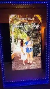 A couple posing for a mirror photo booth outdoors