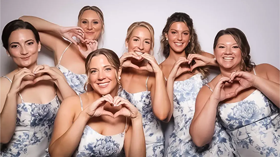 photo booths for all events. a bride and her wedding party posing for a phot booth photo