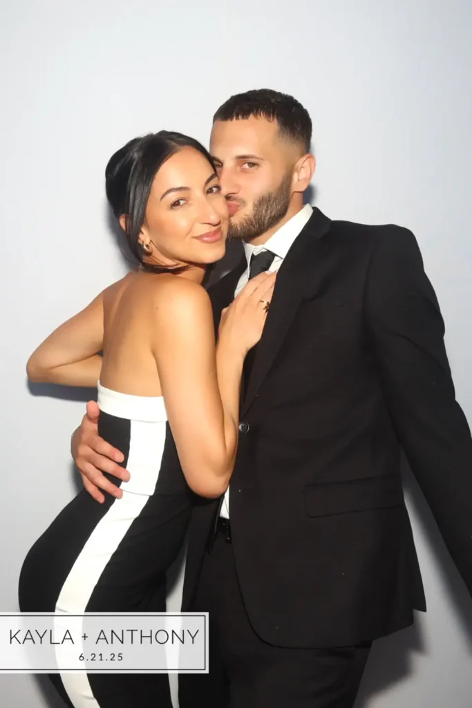 Couple in formal wedding attire embracing for a color GLAM photo booth portrait at a wedding in Meredith, NH