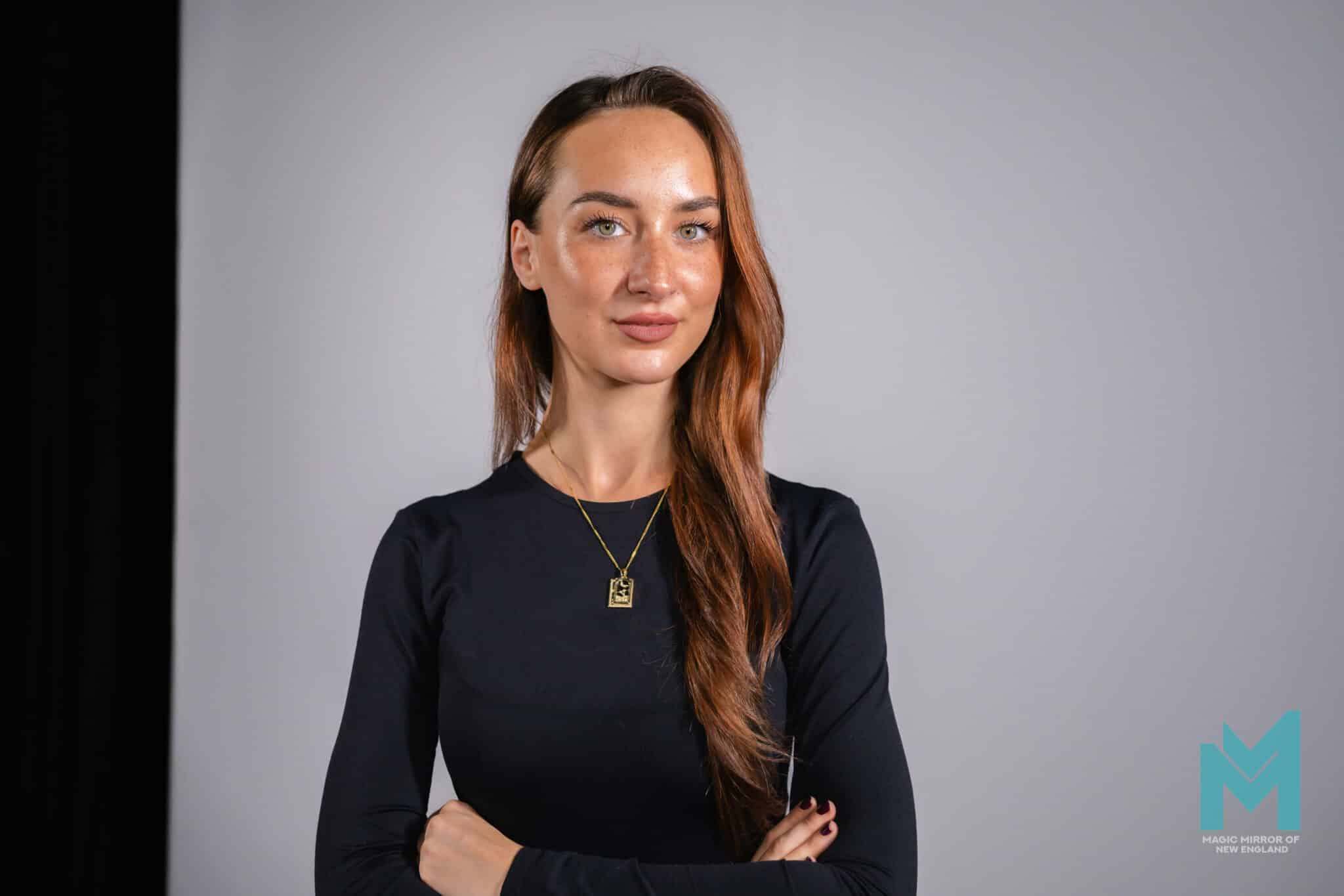 Professional headshot of a woman in a dark top on a grey studio backdrop, captured live at a corporate event