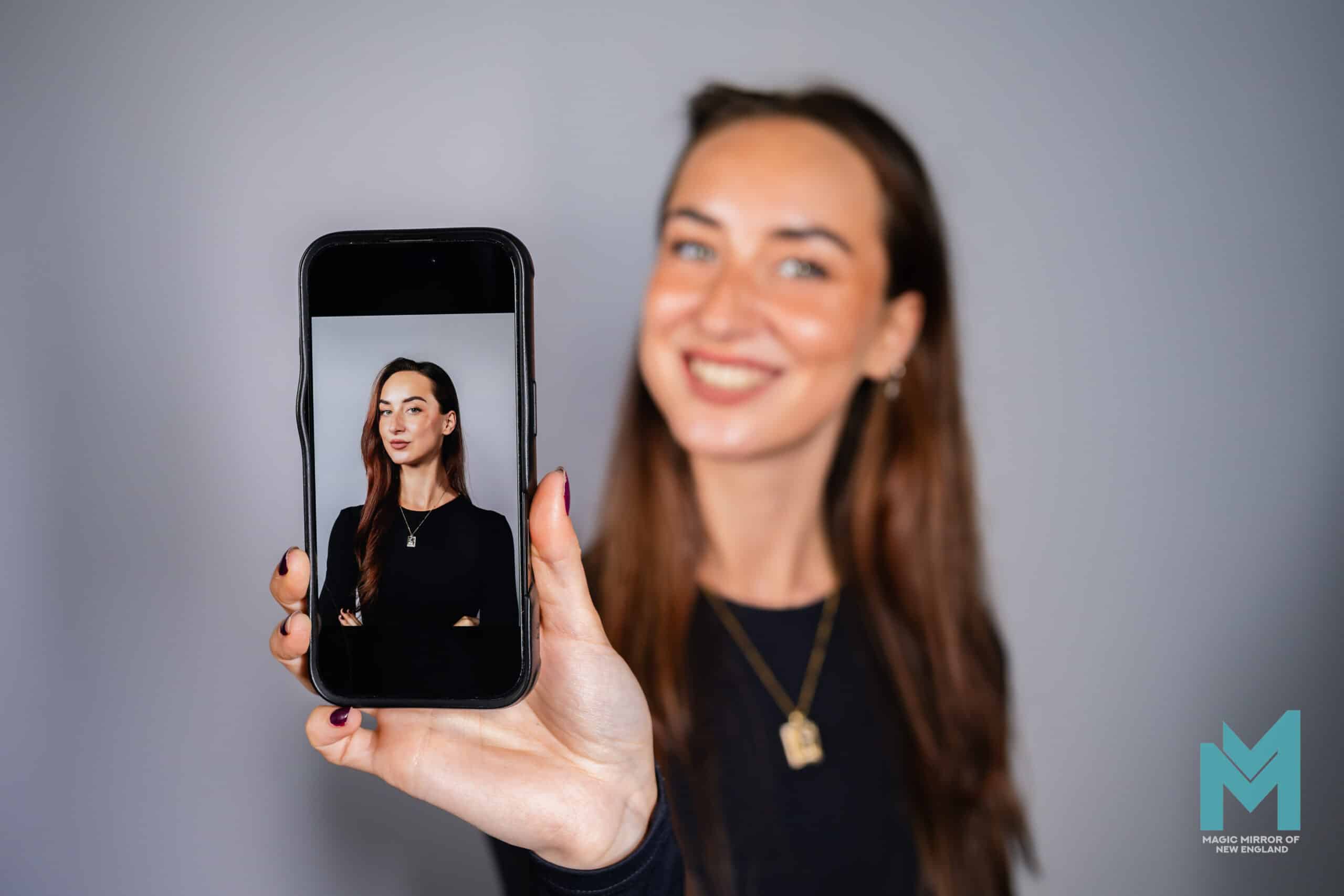Professional AI headshot experience featuring a guest holding a smartphone displaying an instantly delivered studio-quality portrait.