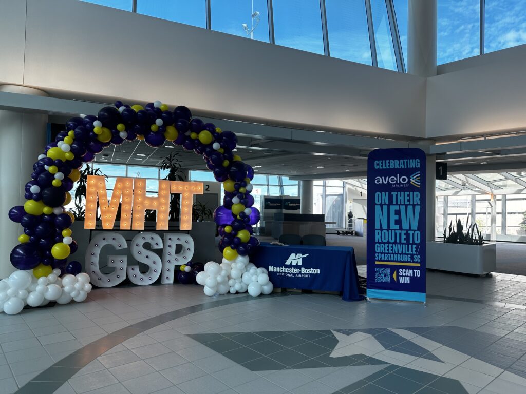 Balloon arch and marquee letter display at Avelo Airlines airport event celebrating a new flight route