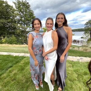 A bride and her friends taking a photo infront of an outdoor wedding