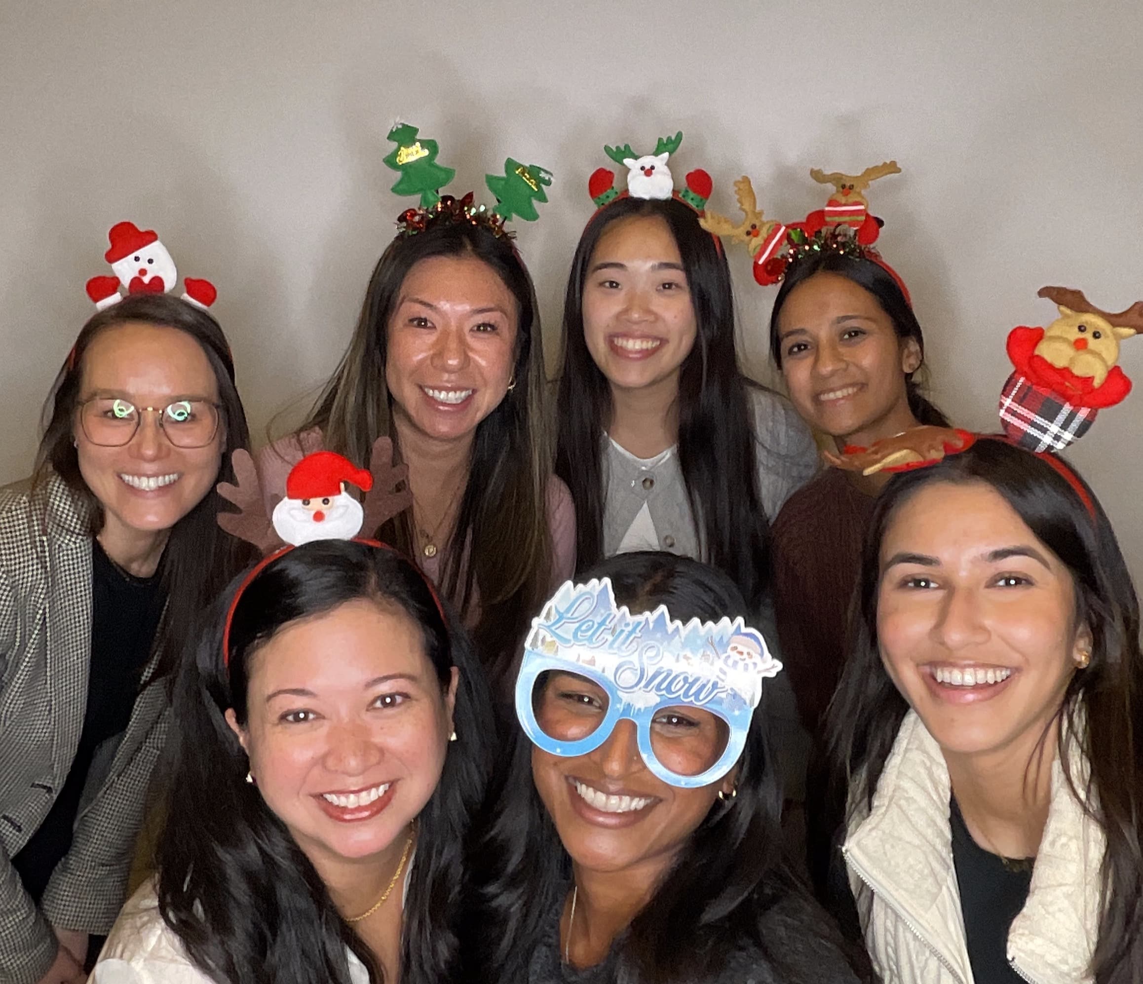 Group of people wearing festive photo booth props and headbands for a Magic Mirror of New England event.