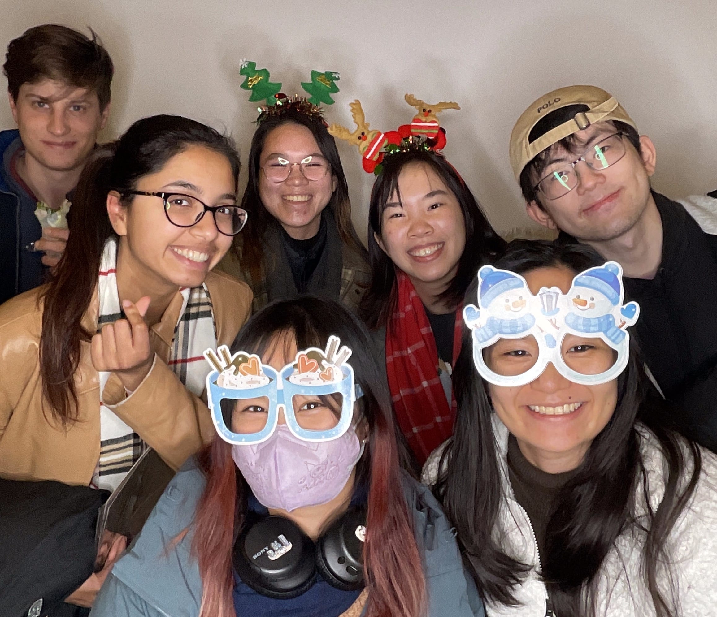 Group of people enjoying a Magic Mirror of New England selfie station with festive props and accessories.