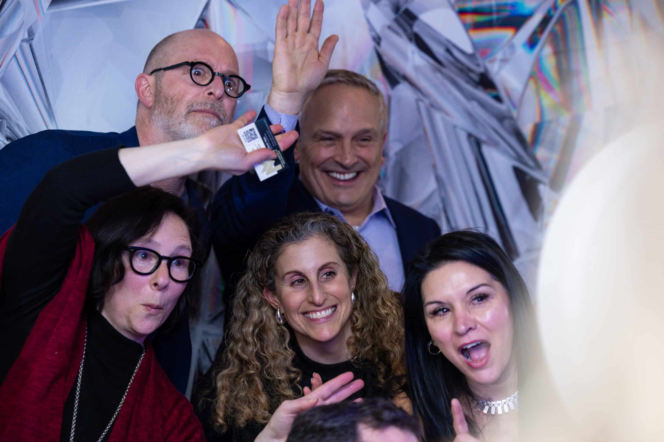 Group of guests laughing and posing close together at a Selfie Station Luxe photo booth