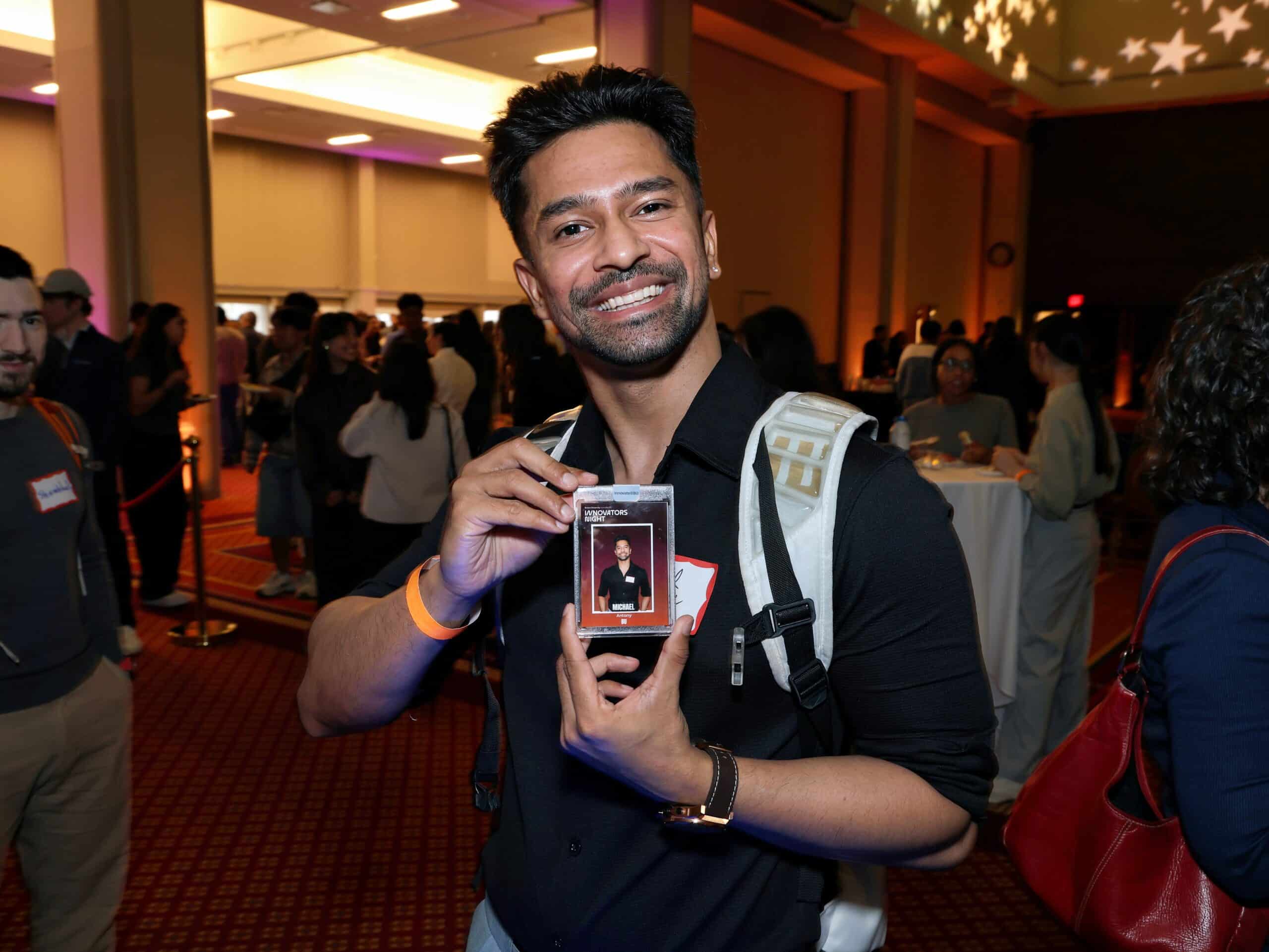 Guest smiling while holding a personalized trading card created during Magic Mirror of New England's interactive Trading Card Experience.