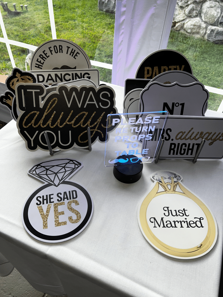 Wedding photo booth props on a table, including "Just Married" and "Say Yes" signs