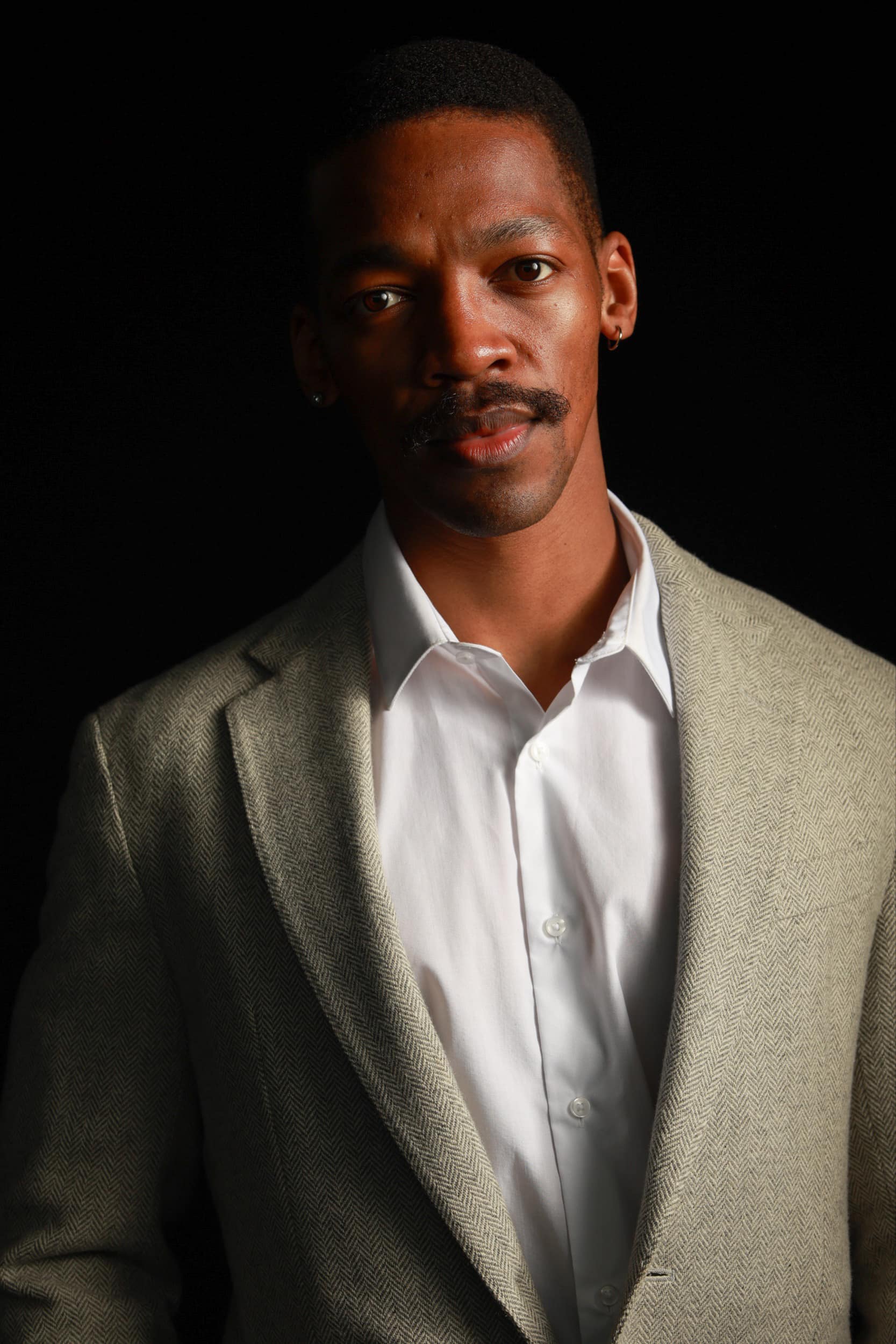 Professional headshot portrait of man in suit and shirt, corporate event photography.