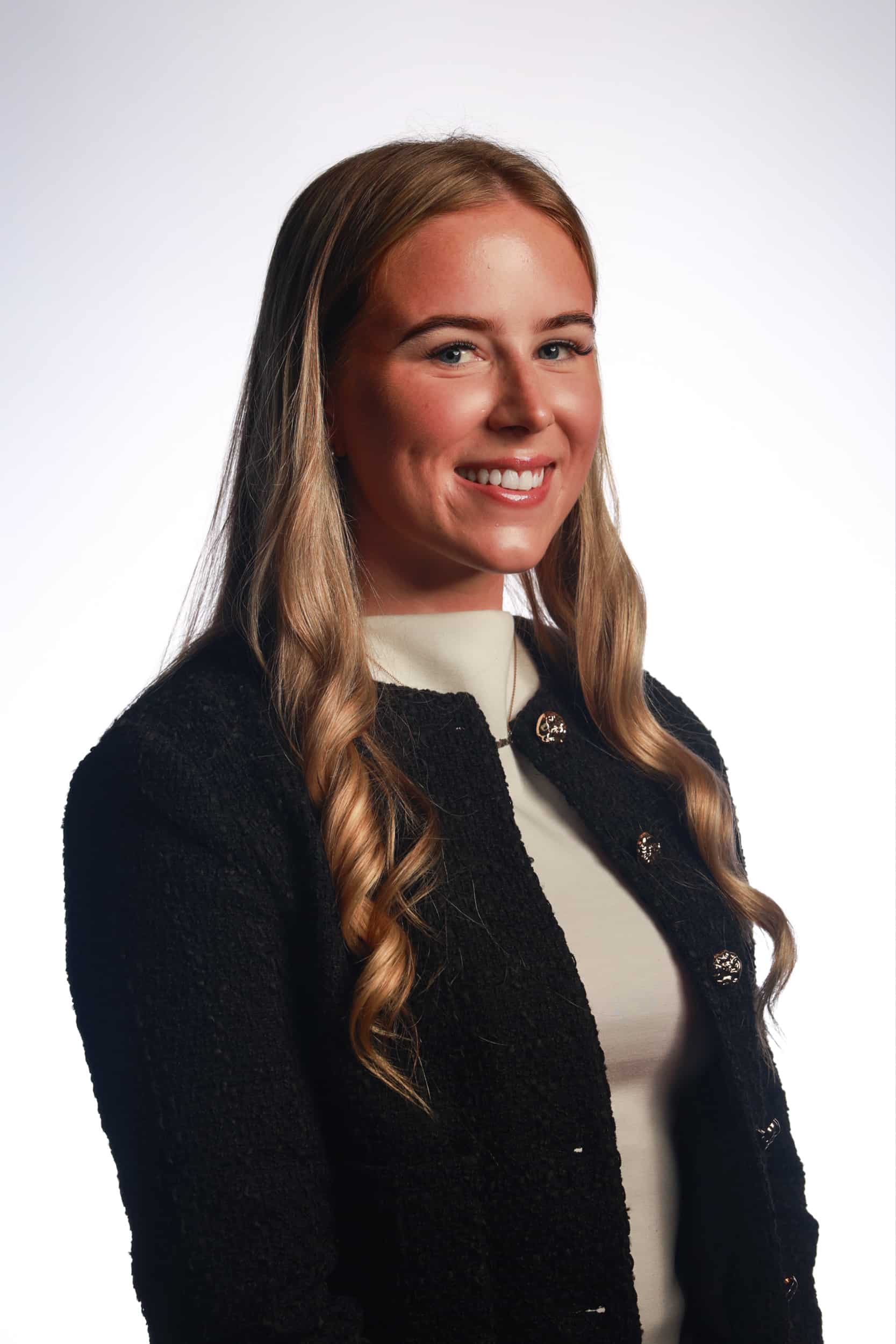 Professional headshot portrait with studio lighting and refined background.