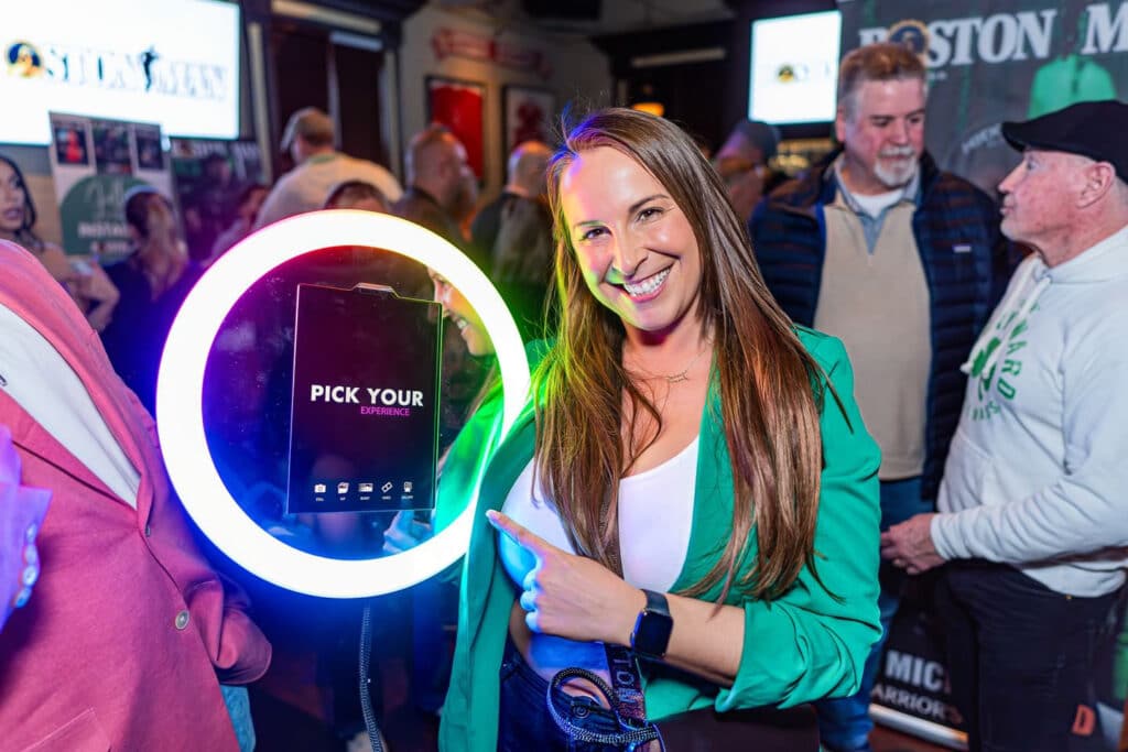 Smiling guest holding the roaming photo booth ring light at a corporate event