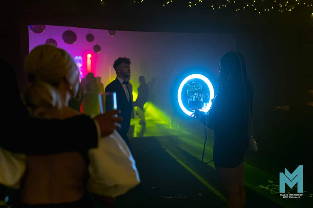 Guests dancing near the roaming photo booth ring light at an evening event