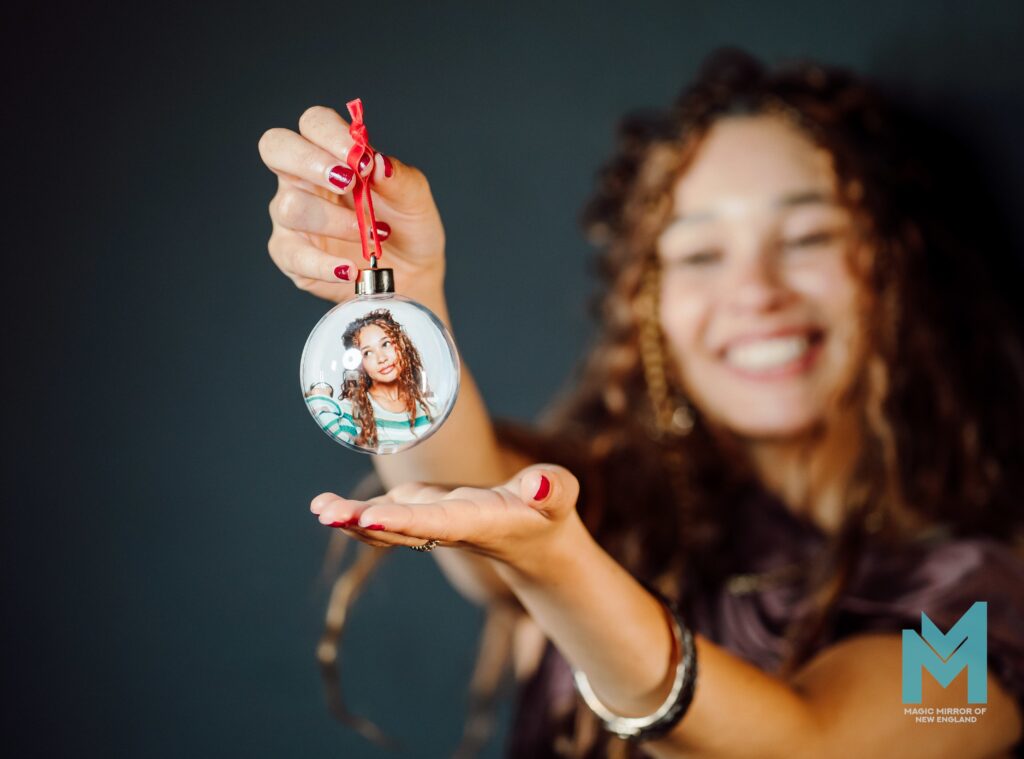 Woman holding a printed photo inside a clear Holiday Bubble Ornament keepsake, Magic Mirror of New England in New Hampshire