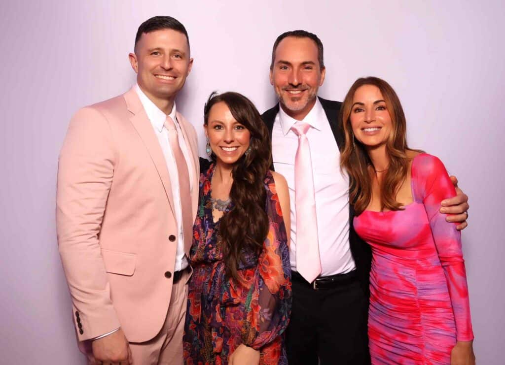Four guests in formal attire smiling together in a photo booth at a charity nonprofit fundraiser in Bedford, New Hampshire