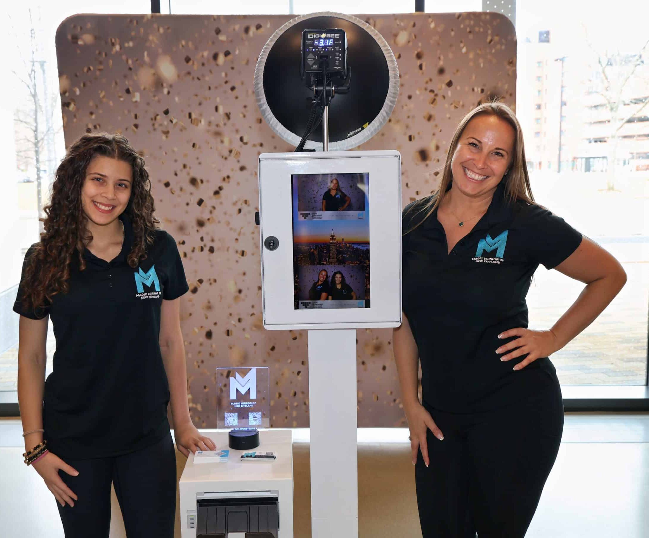 Two Magic Mirror of New England photo booth attendants smiling together at an event in New Hampshire