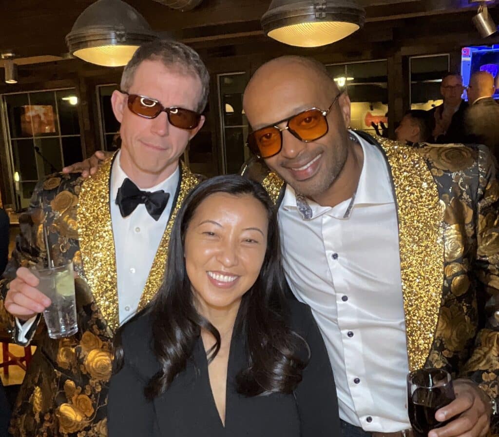 Three guests in gold sequin jackets and tinted sunglasses at a Cliff House Maine event captured by the roaming photographer