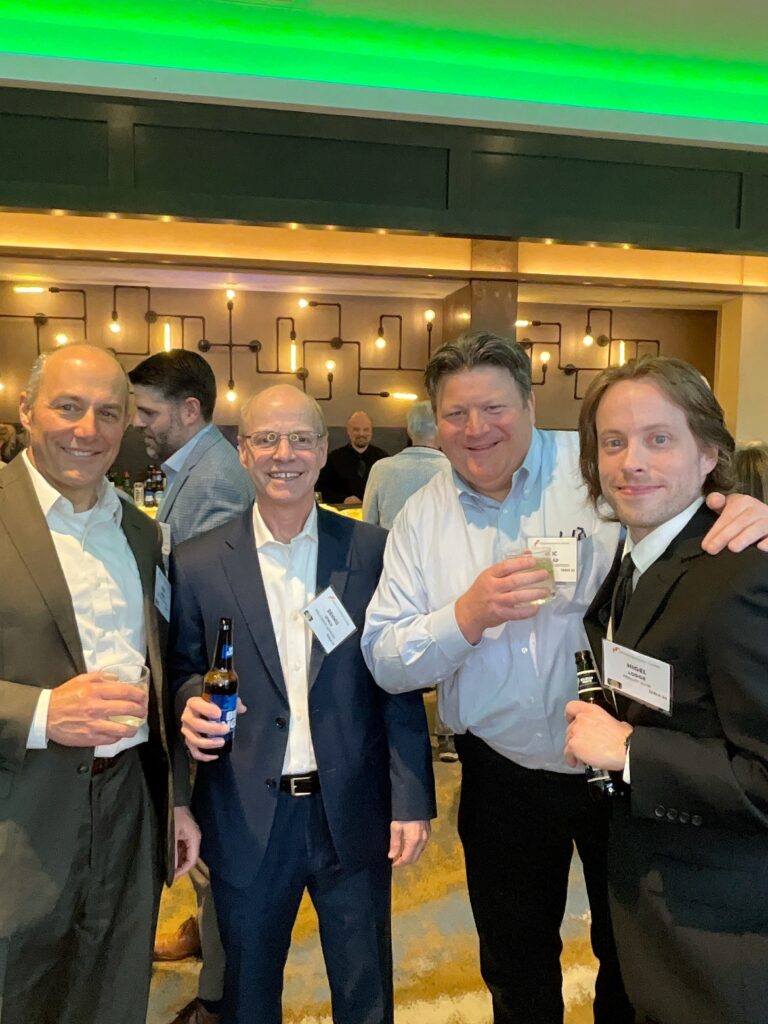 Four colleagues with drinks posing for the roaming photo booth at a Manchester, NH awards event