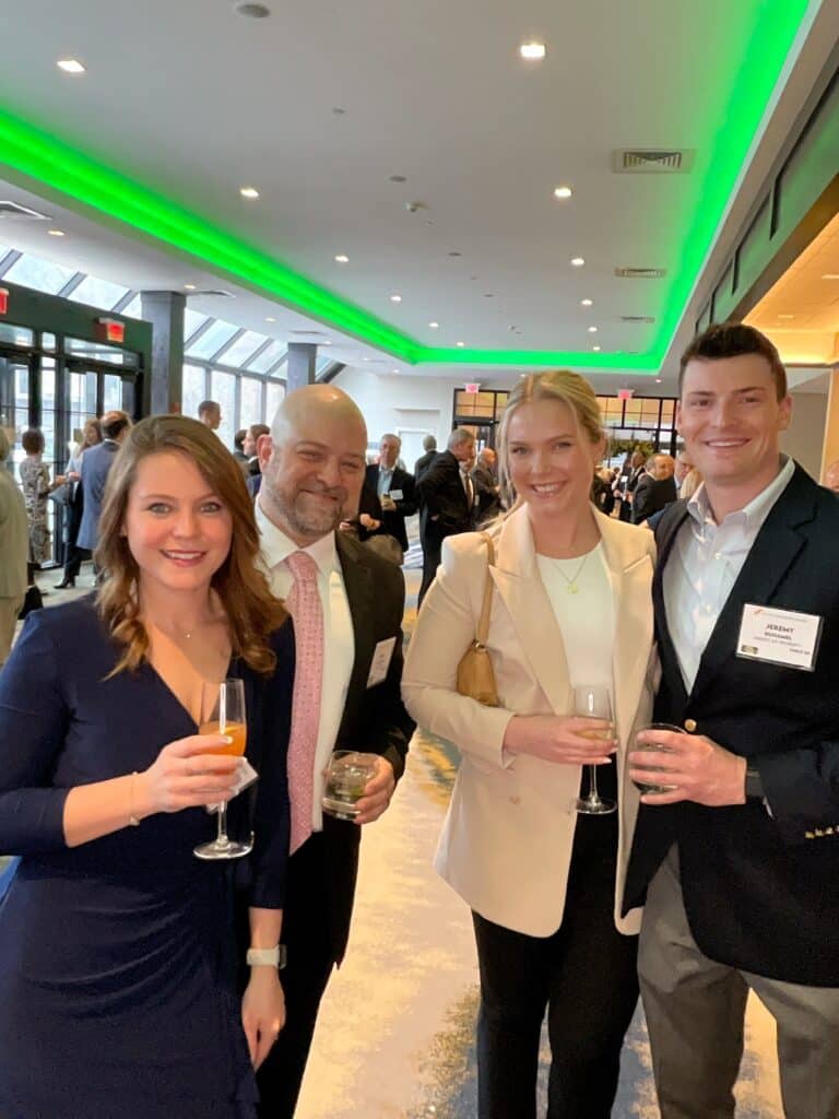 Four guests smiling at the cocktail hour roaming photo booth at a Manchester, NH awards event