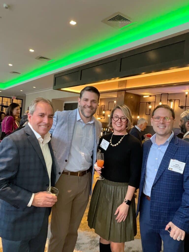 Group of four guests smiling for the roaming photo booth at a Manchester, NH business awards event