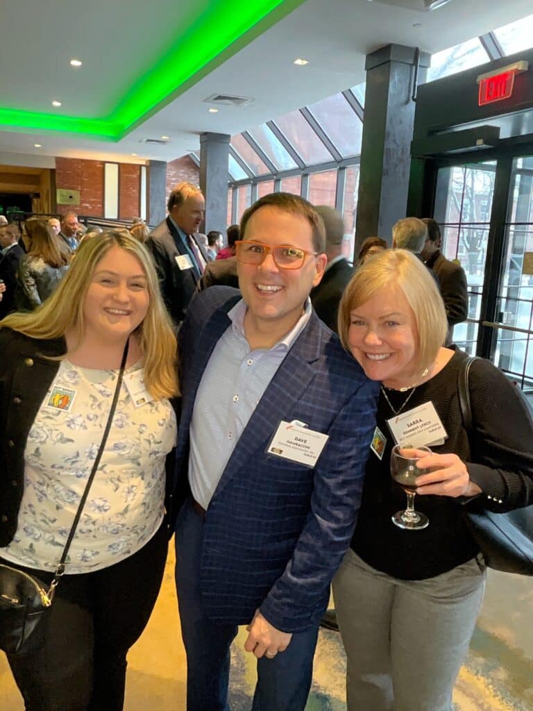 Three guests laughing together in the roaming photo booth at a Manchester, NH awards event