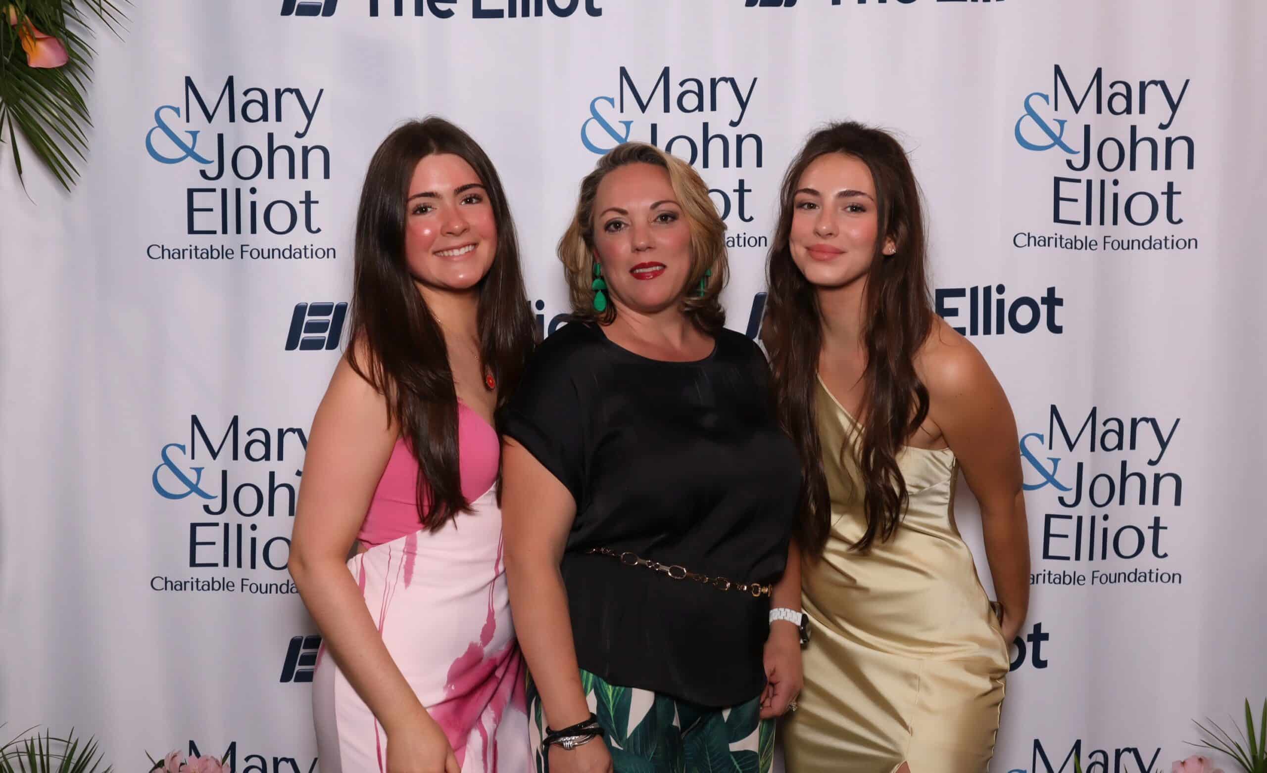 Three guests in dresses pose at the Elliot Health System Gala photo booth