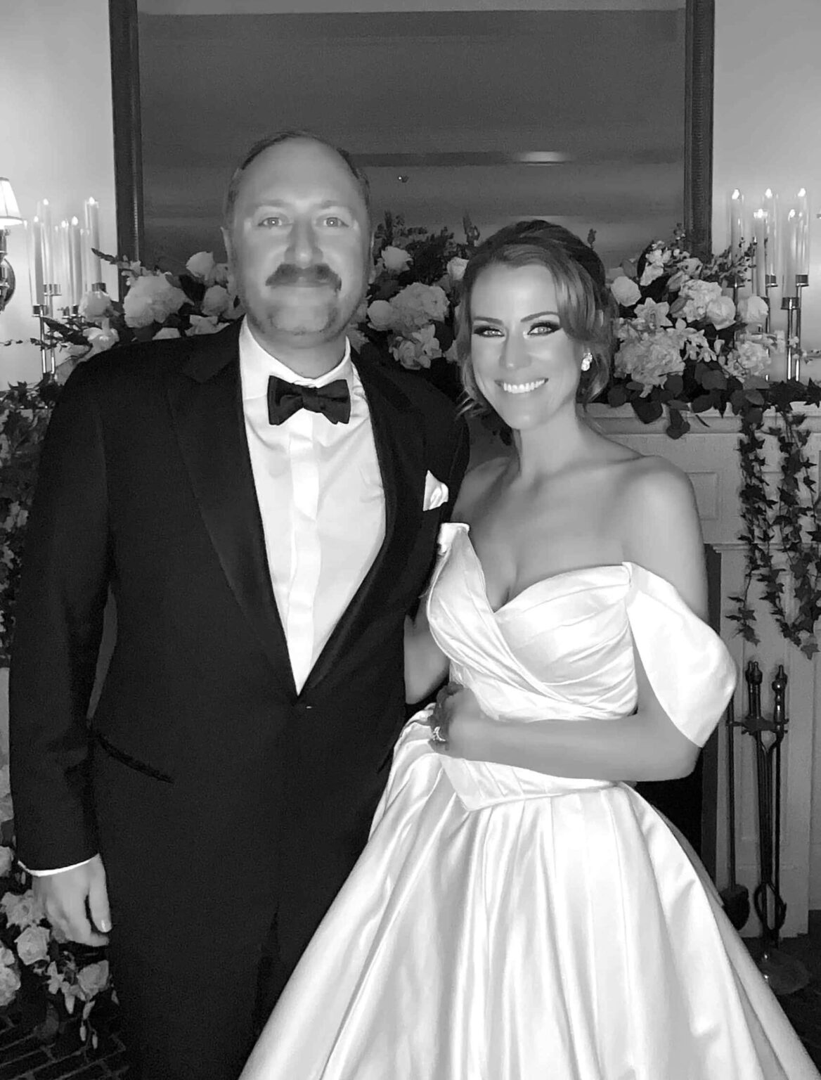 Full black and white GLAM portrait of a groom in a black tuxedo and a bride in a white satin gown at a Dream Booth wedding