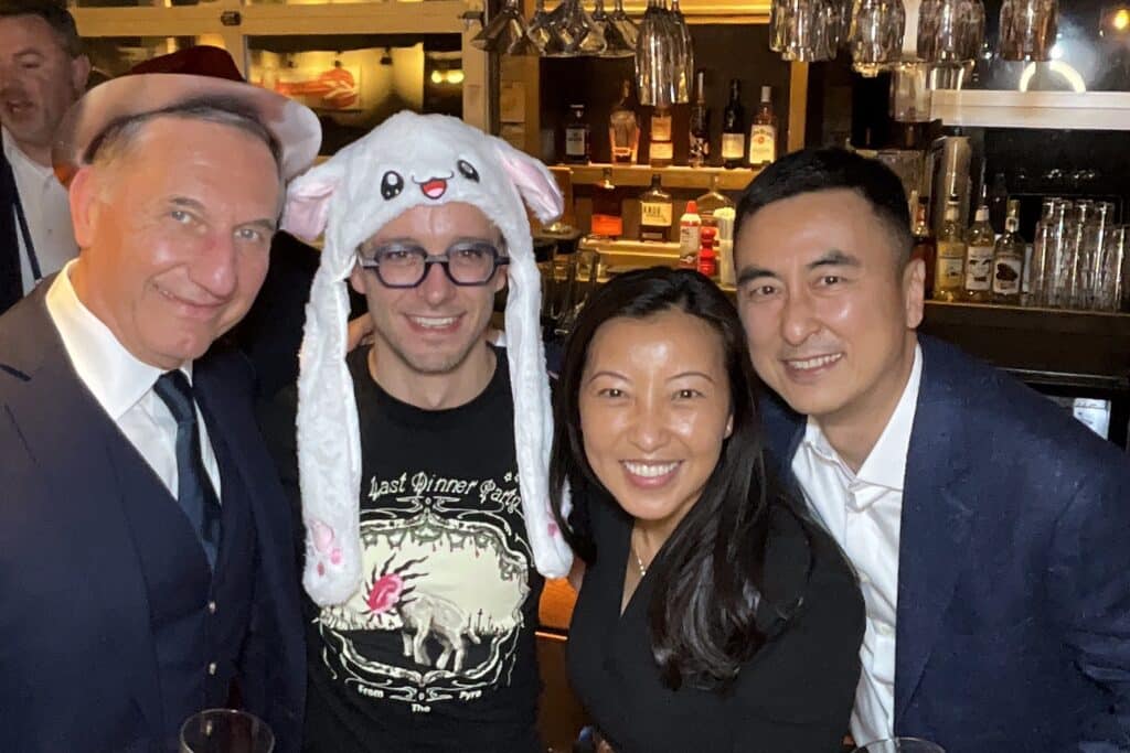Guests in a bunny hat and festive hats having fun with the roaming photo booth at a Southern Maine party