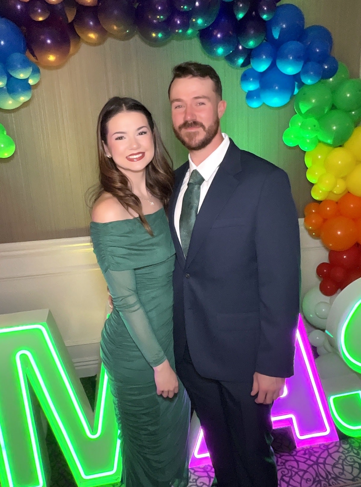 Couple at the roaming photo booth in front of a rainbow balloon arch at the Wizard of Oz themed animal shelter gala at Manchester Country Club in Bedford, NH